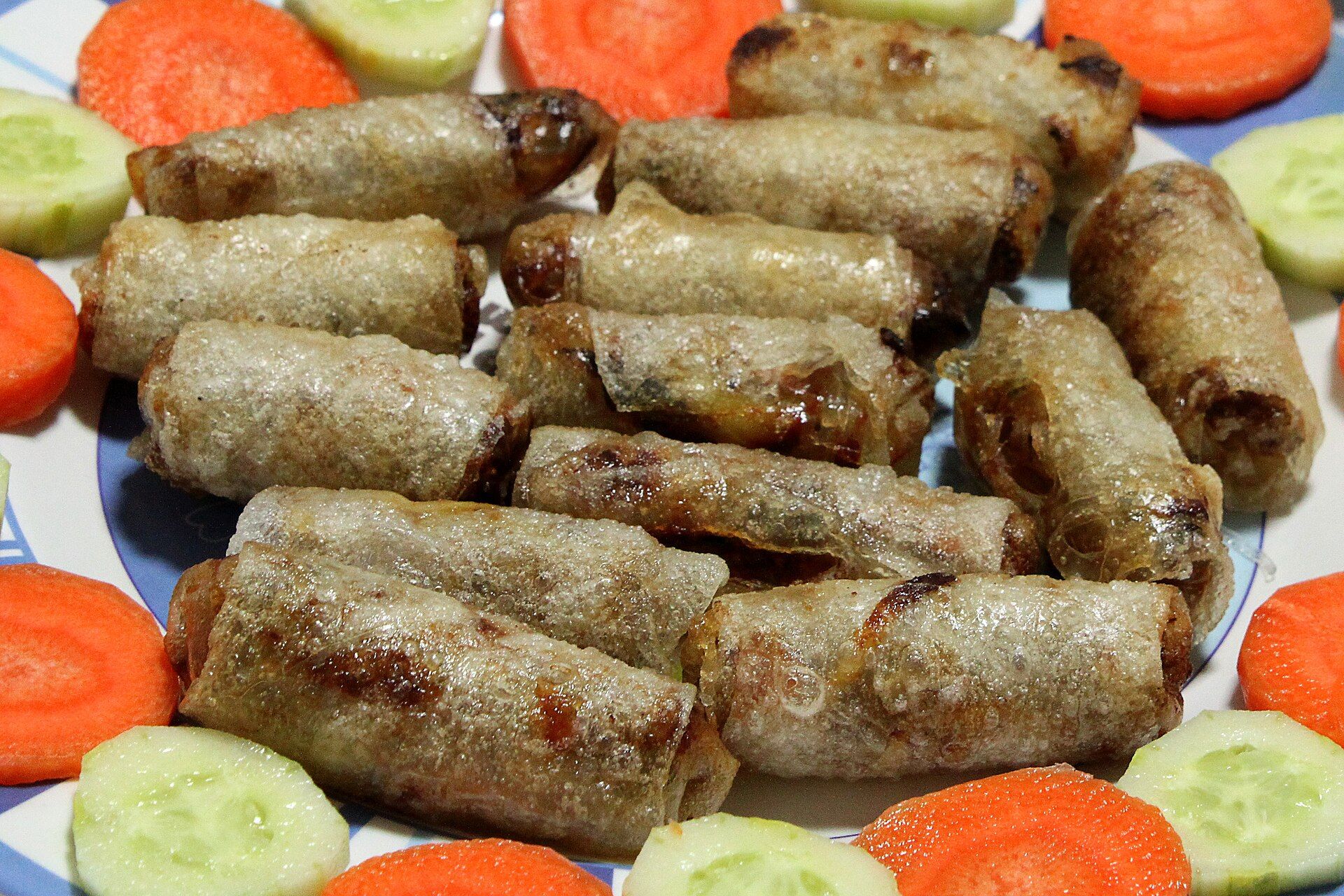 Des rouleaux frits croustillants servis avec carottes et concombre