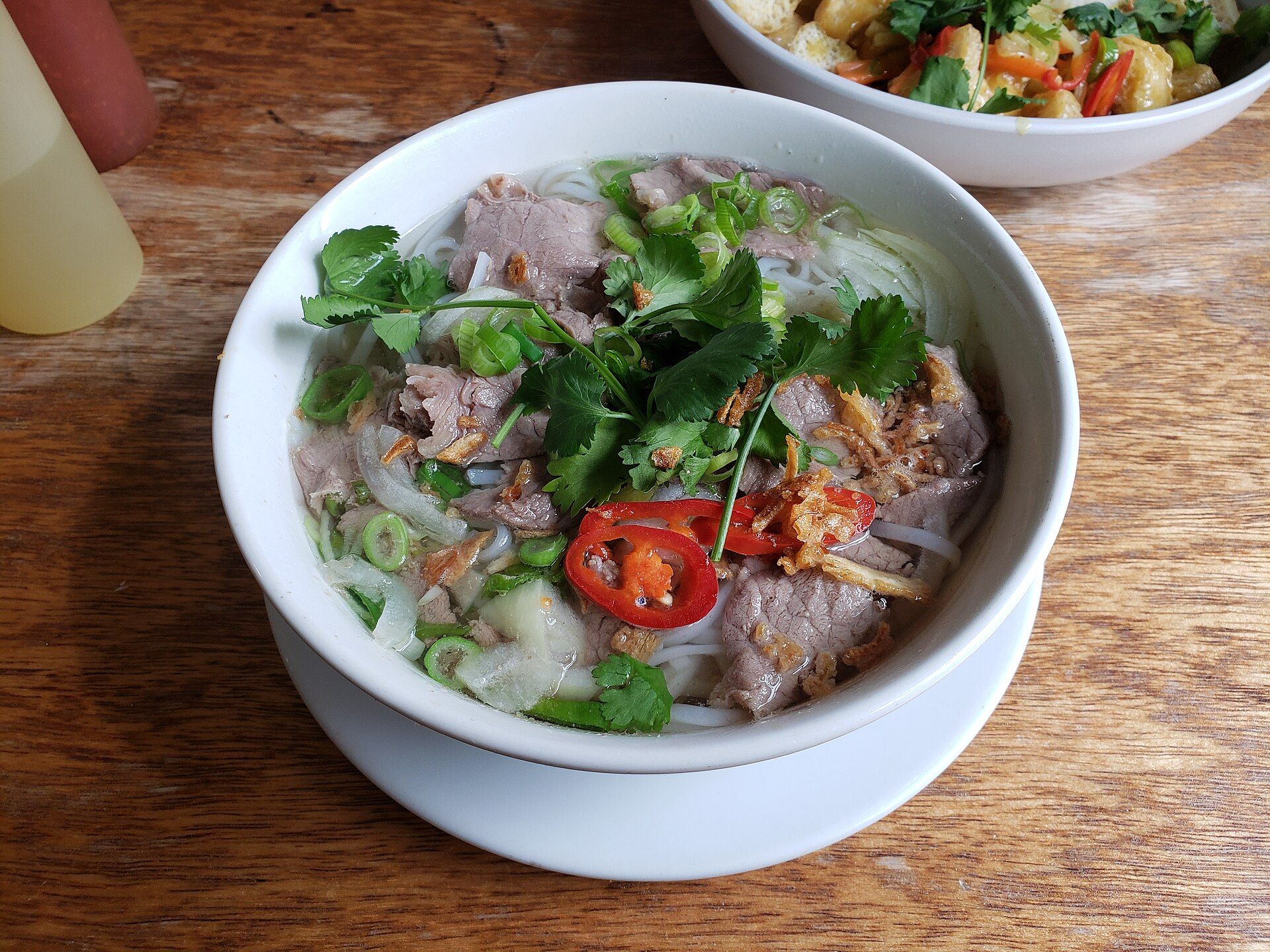 Un bol de soupe de bœuf aux herbes, piment et oignons